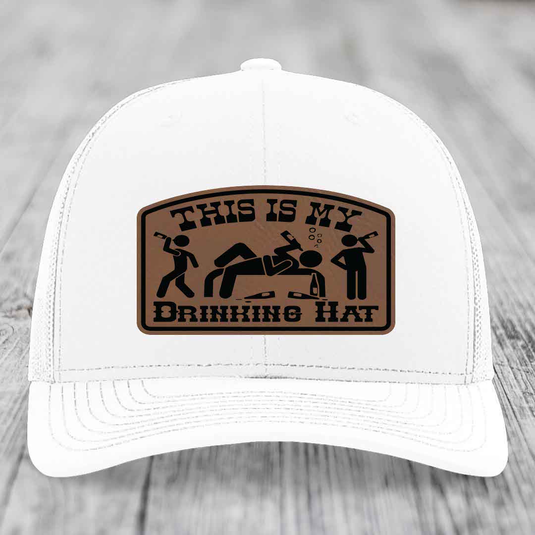 White trucker hat with brown leather patch reading &