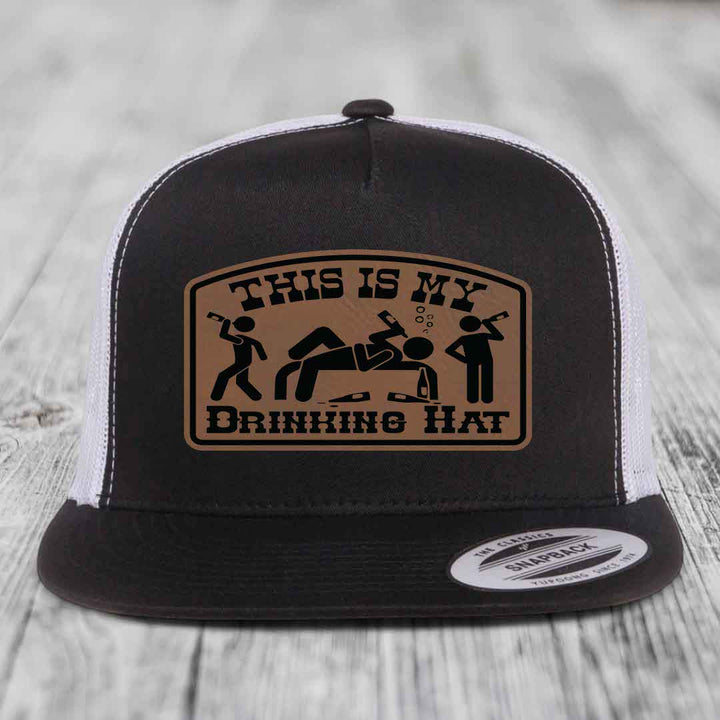 Black and white trucker hat with brown leather patch reading &