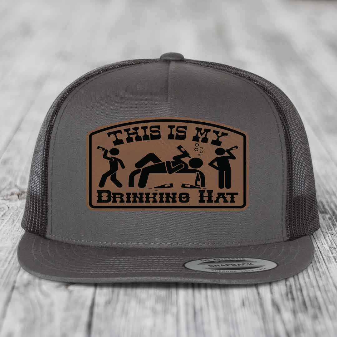 Grey trucker hat with brown leather patch reading &