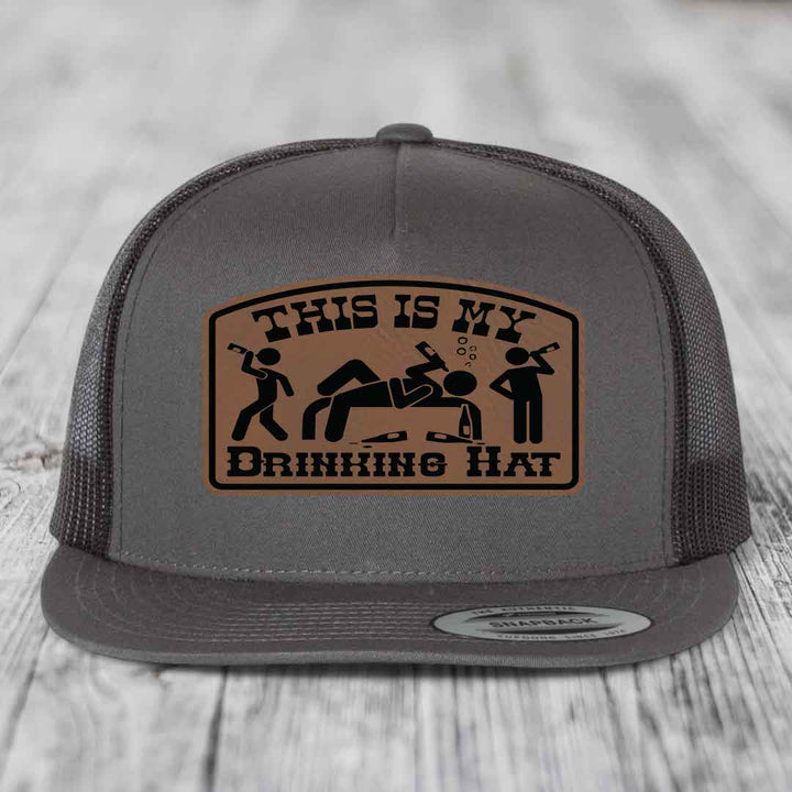 Grey trucker hat with brown leather patch reading &