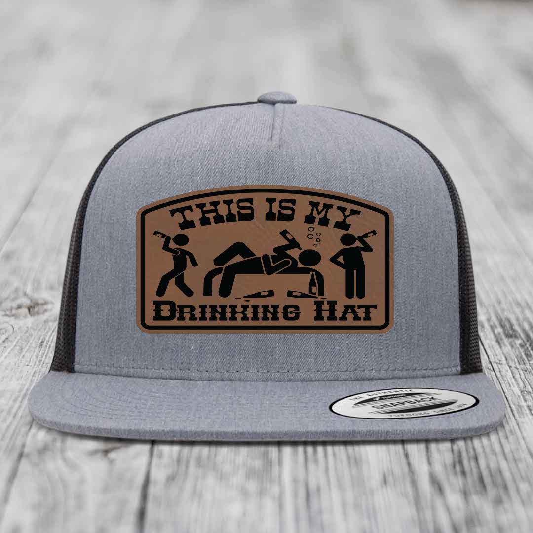 Grey trucker hat with brown leather patch reading &