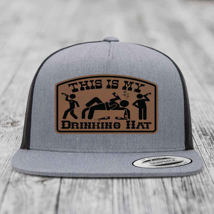 Grey trucker hat with brown leather patch reading &