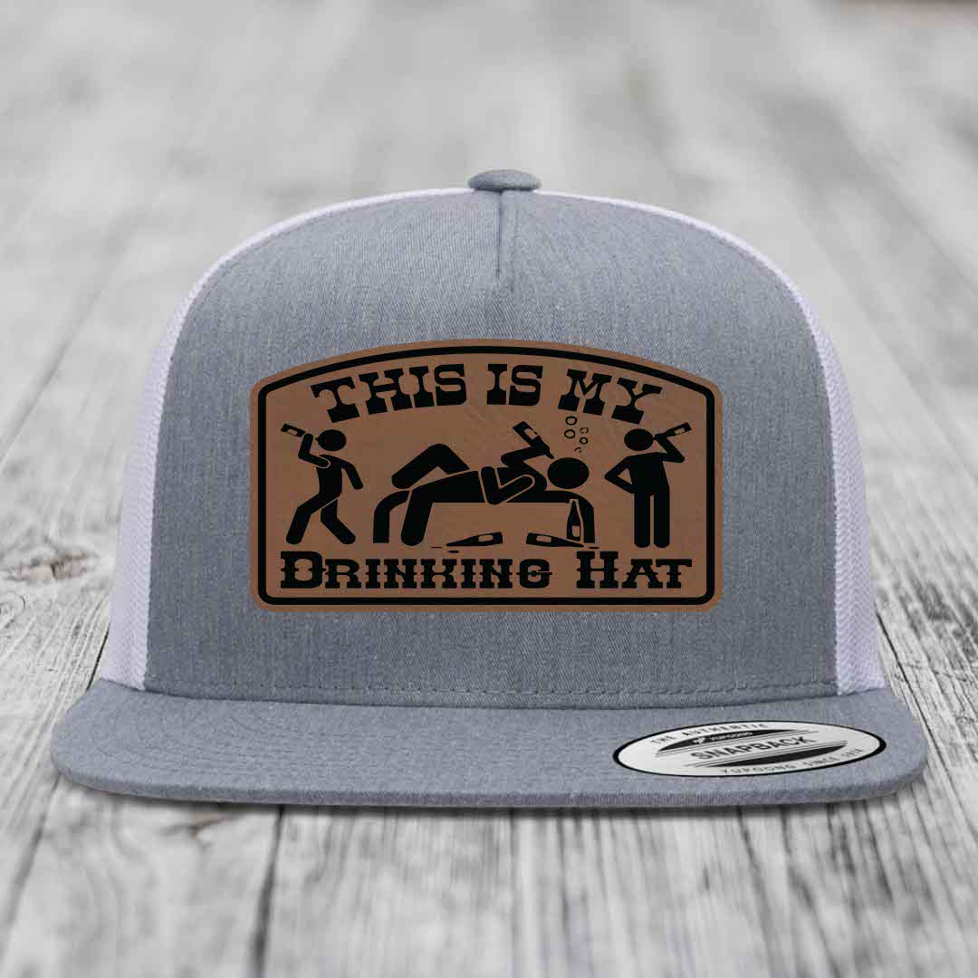 Grey trucker hat with brown leather patch reading &