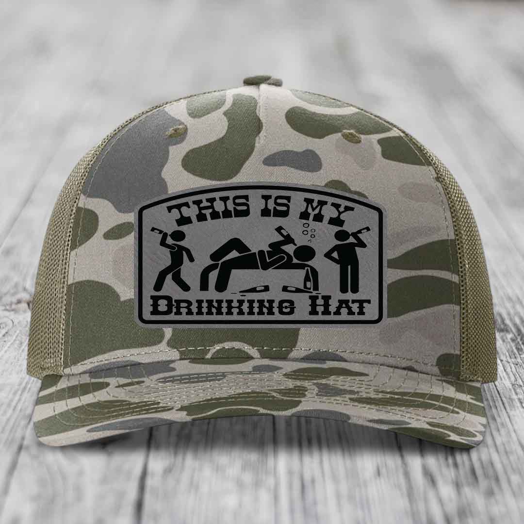 Camouflage trucker hat with black leatherette patch reading &