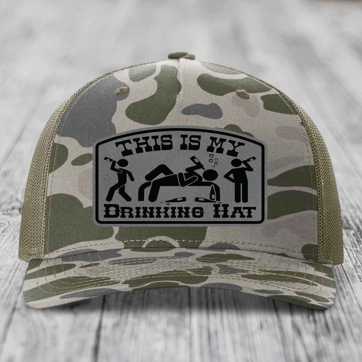 Camouflage trucker hat with black leatherette patch reading &