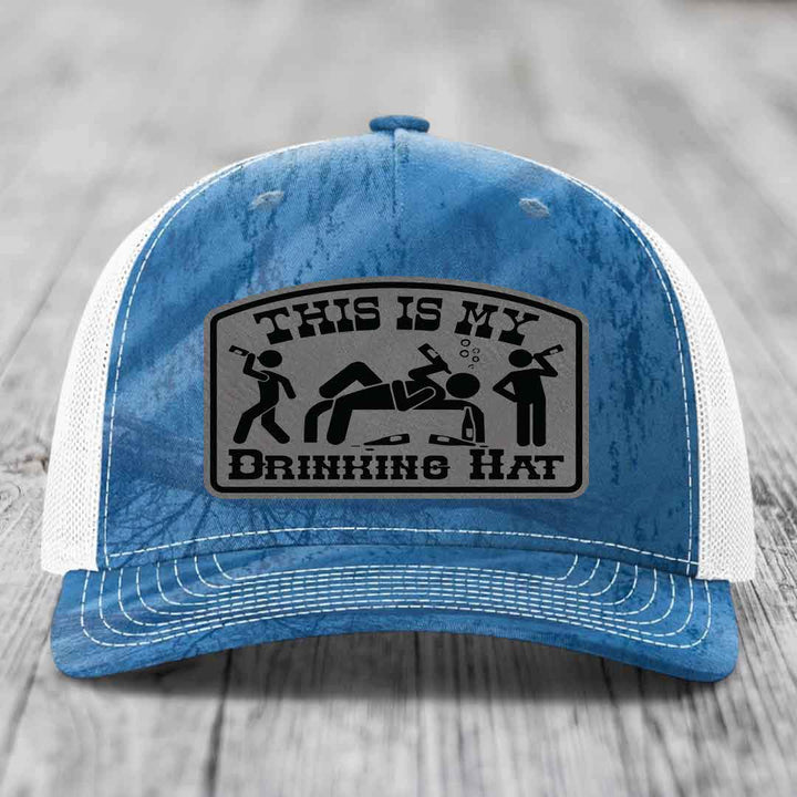 Blue and white trucker hat with a gray leatherette patch that reads &