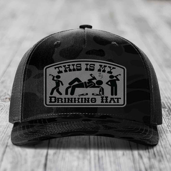 Black camouflage trucker hat with a rectangular patch reading &