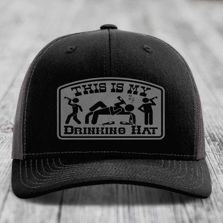 Black trucker hat with a gray patch that reads &