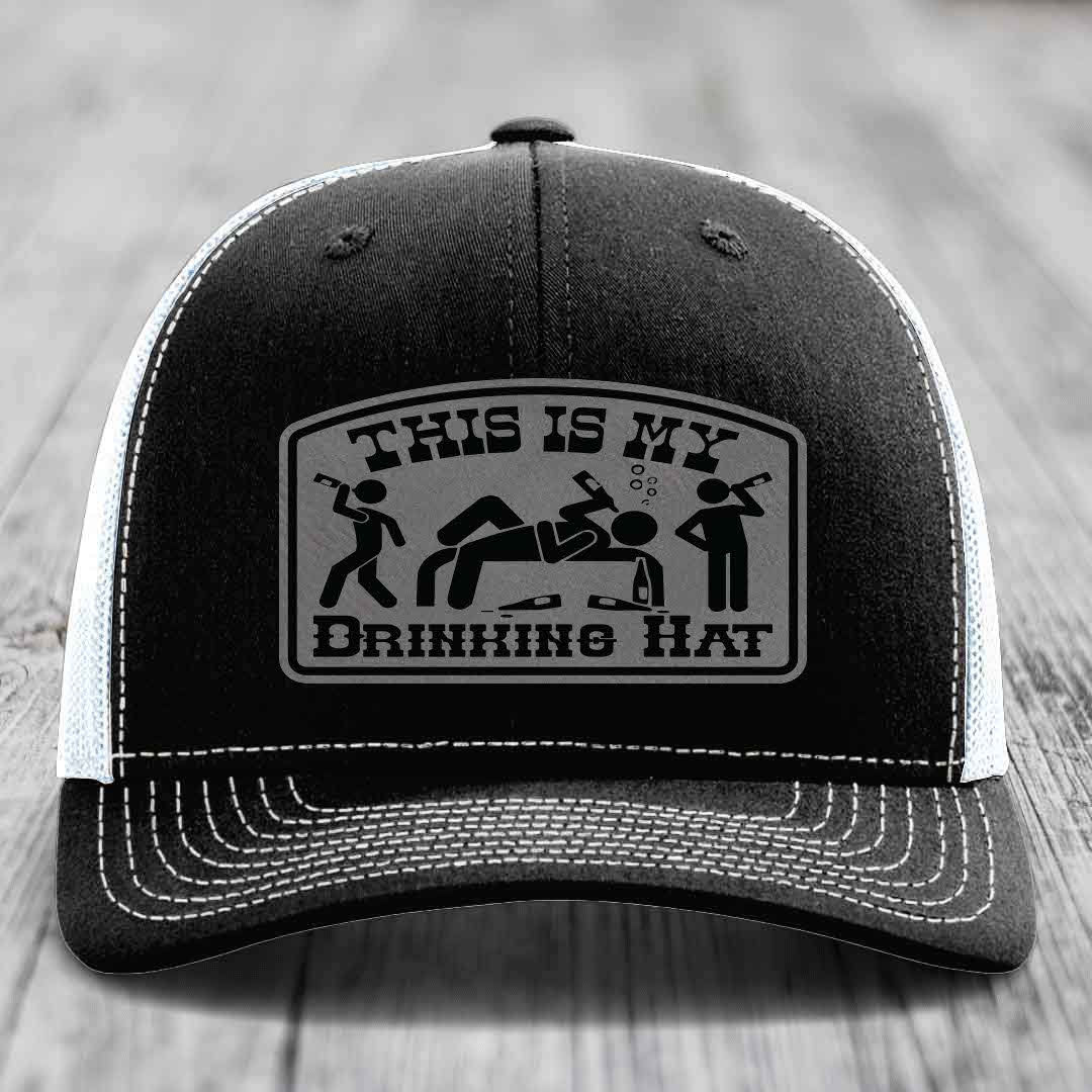 Black trucker hat with white stitching and a gray patch reading &