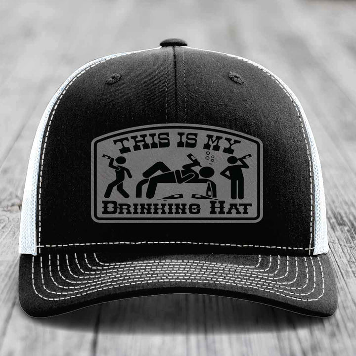 Black trucker hat with white stitching and a gray patch reading &