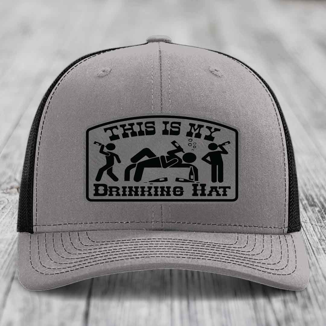Grey trucker hat with black patch reading &