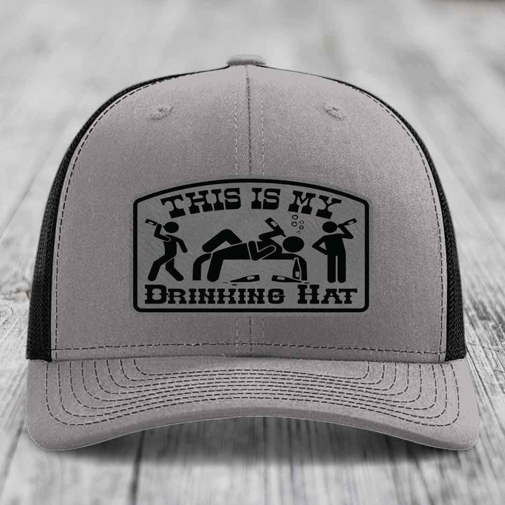 Grey trucker hat with black patch reading &