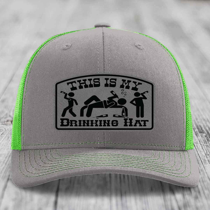 Grey trucker hat with neon green mesh and a black &