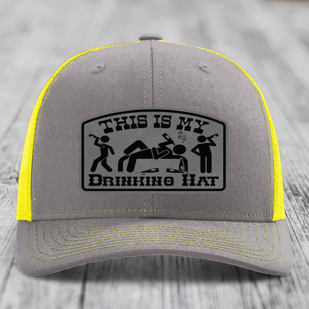 Grey trucker hat with yellow mesh back and black patch reading &