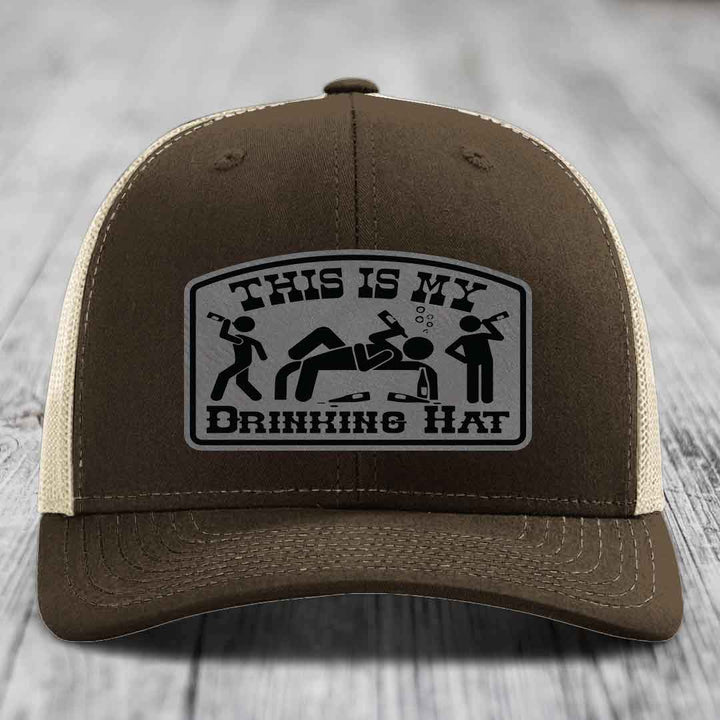 Brown trucker hat with a silver patch that reads &