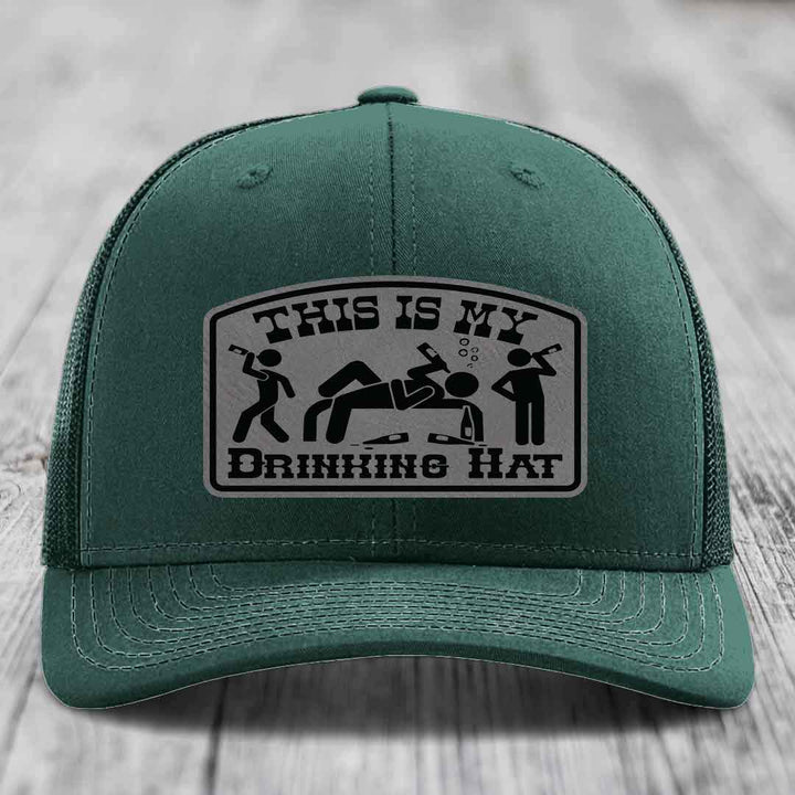 Green trucker hat with a gray leatherette patch reading &