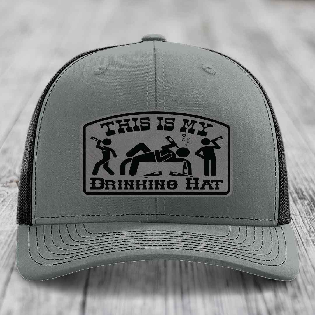 Grey trucker hat with black leatherette patch reading &
