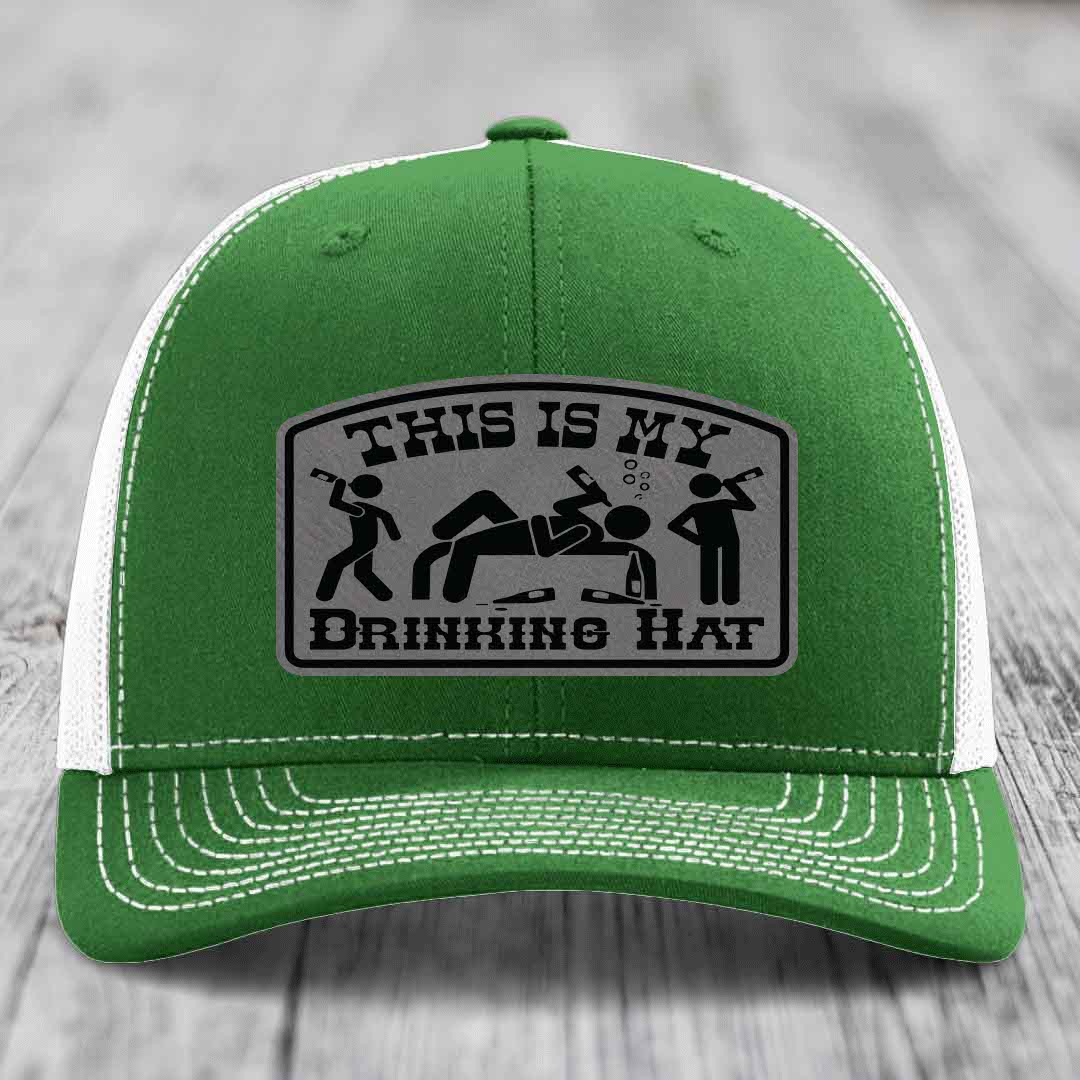 Green trucker hat with white mesh back and stitching, featuring a gray leatherette patch that reads &