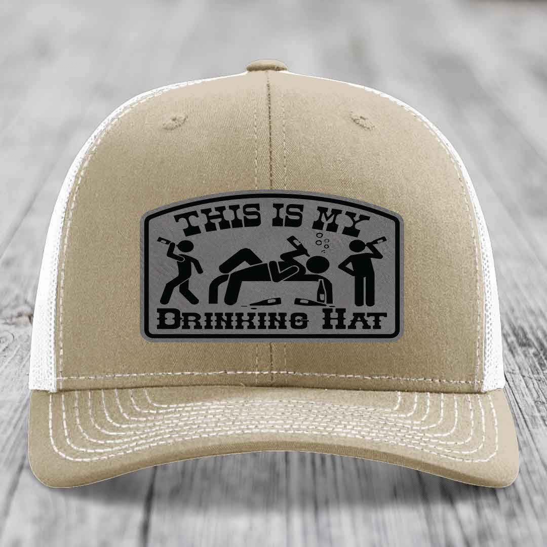 Tan trucker hat with a black and grey leatherette patch that reads &