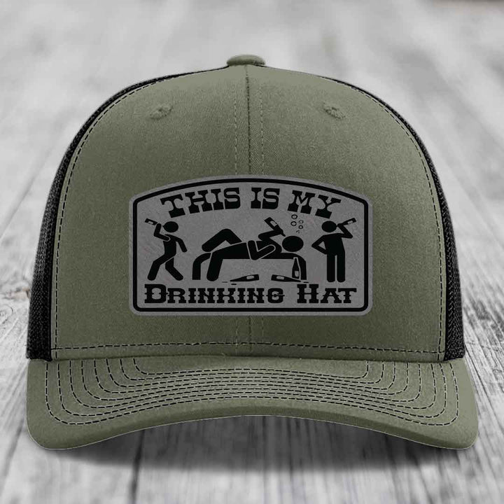 Olive green trucker hat with black mesh back and a rectangular patch that reads &