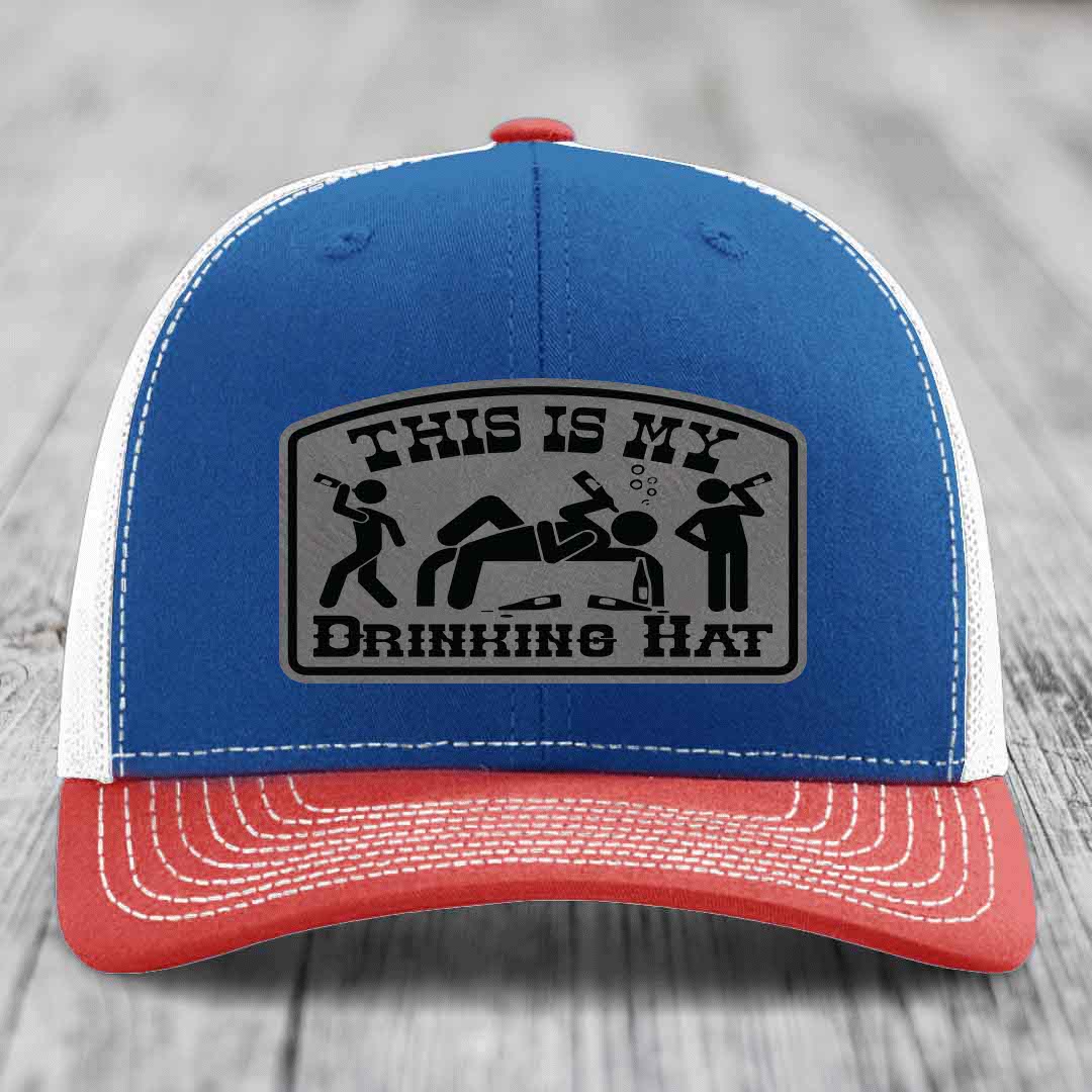 Blue and red trucker hat with a gray leatherette patch that reads &