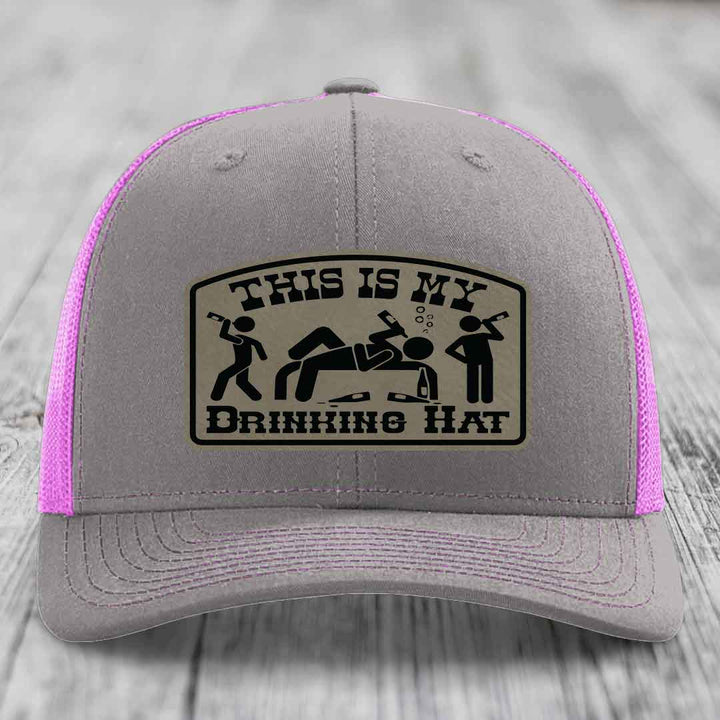 Grey trucker hat with pink mesh sides and a &