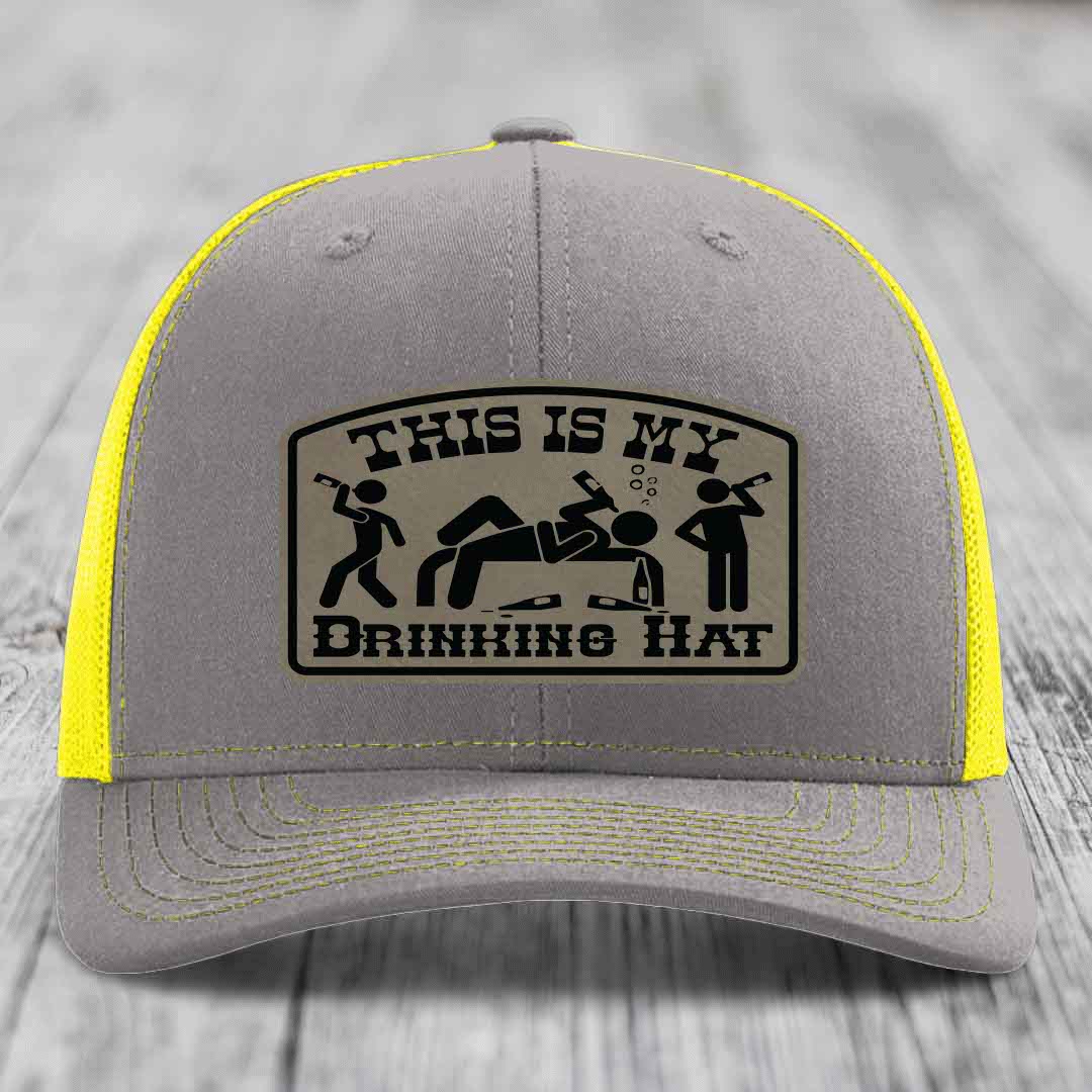 Grey trucker hat with yellow mesh and stitching, featuring a &