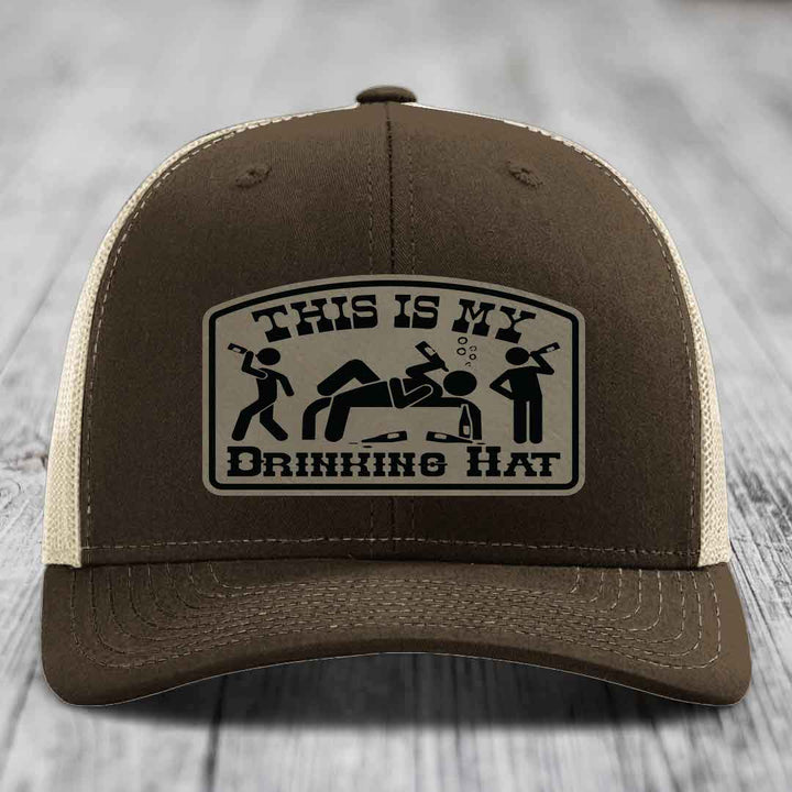 Brown trucker hat with beige mesh back and black patch reading &