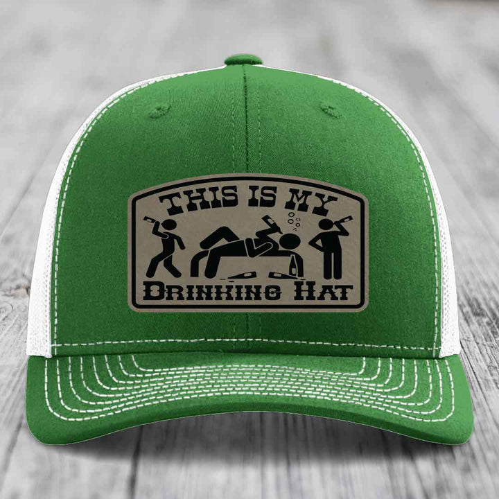 Green trucker hat with white mesh back and stitching, featuring a beige leatherette patch that reads &