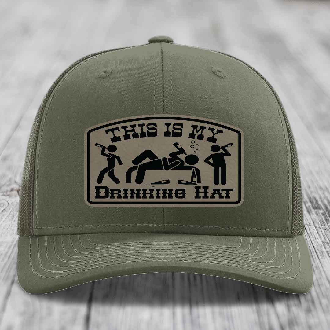 Olive green trucker hat with a beige leather patch that reads &