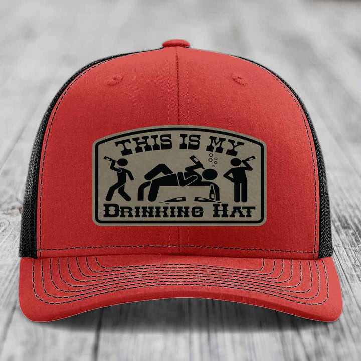 Red trucker hat with black mesh back and a beige leatherette patch that reads &