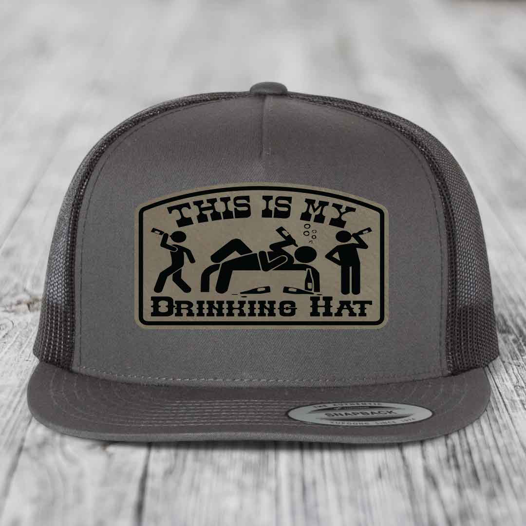 Grey trucker hat with a beige patch that reads &