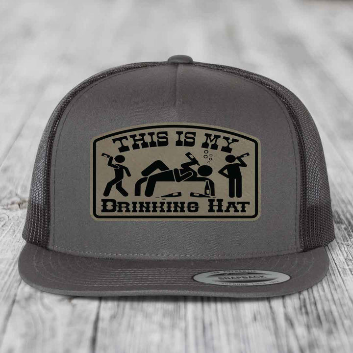 Grey trucker hat with a beige patch that reads &