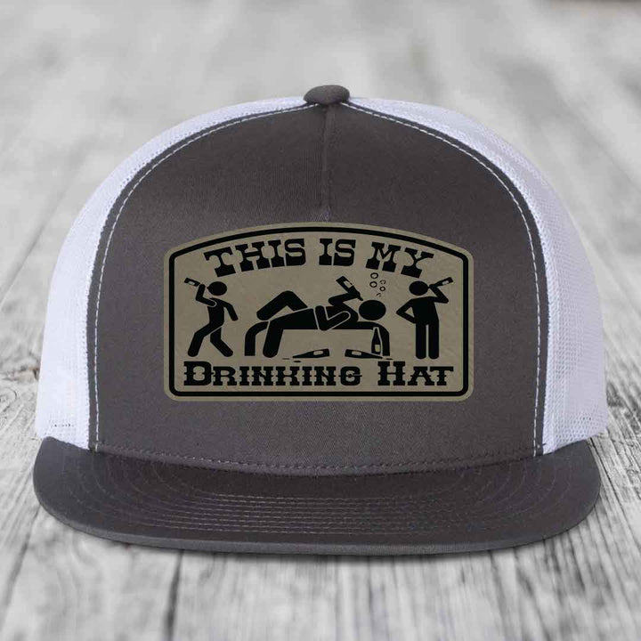 Grey trucker hat with beige leather patch reading &