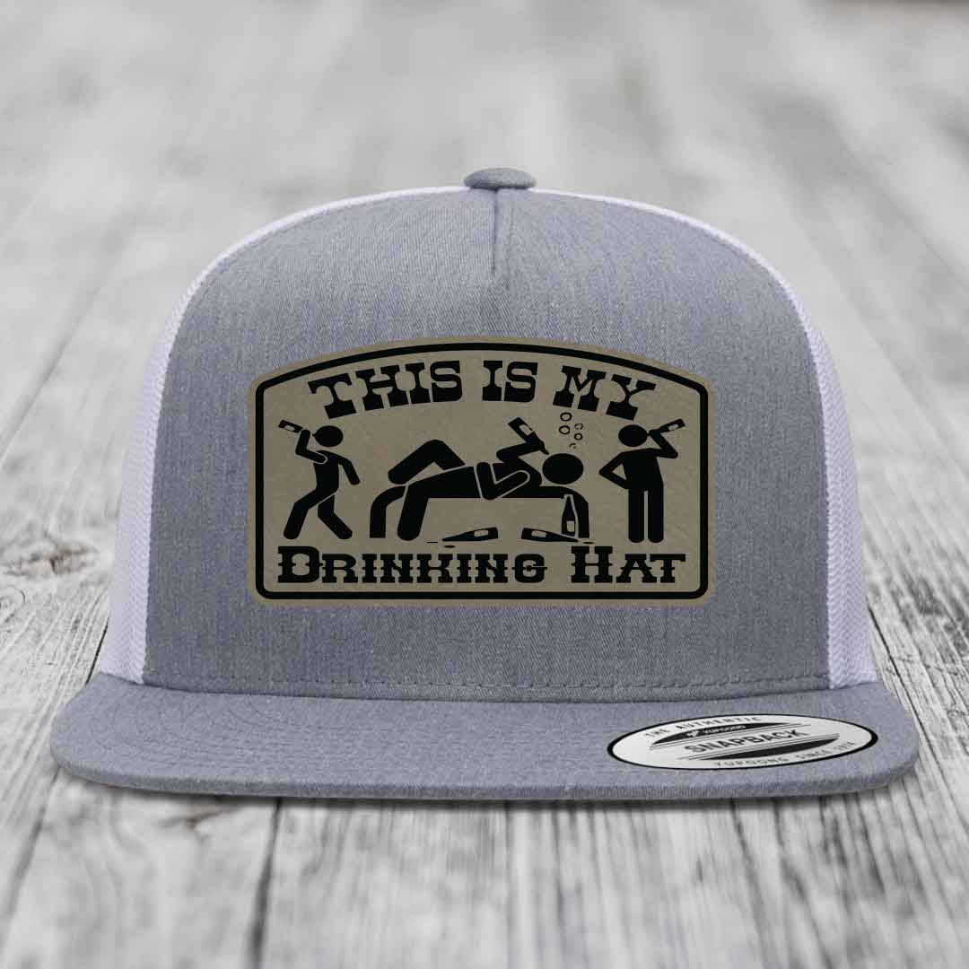 Grey trucker hat with a beige patch that reads &