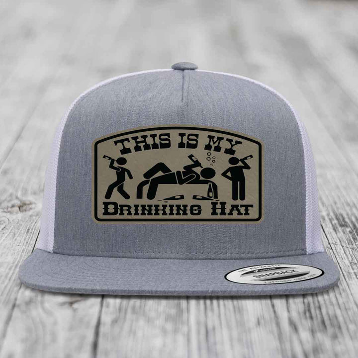 Grey trucker hat with a beige patch that reads &