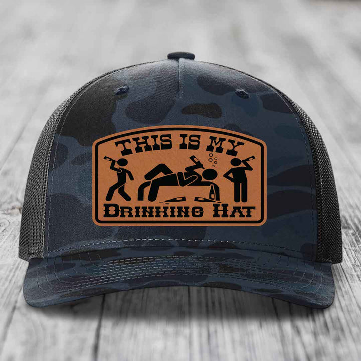 Camouflage trucker hat with brown leather patch reading &