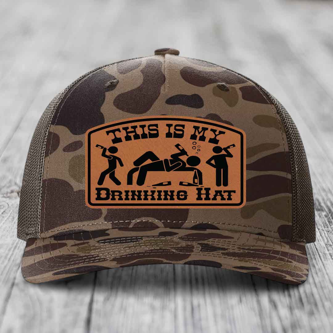 Camouflage trucker hat with brown leather patch reading &