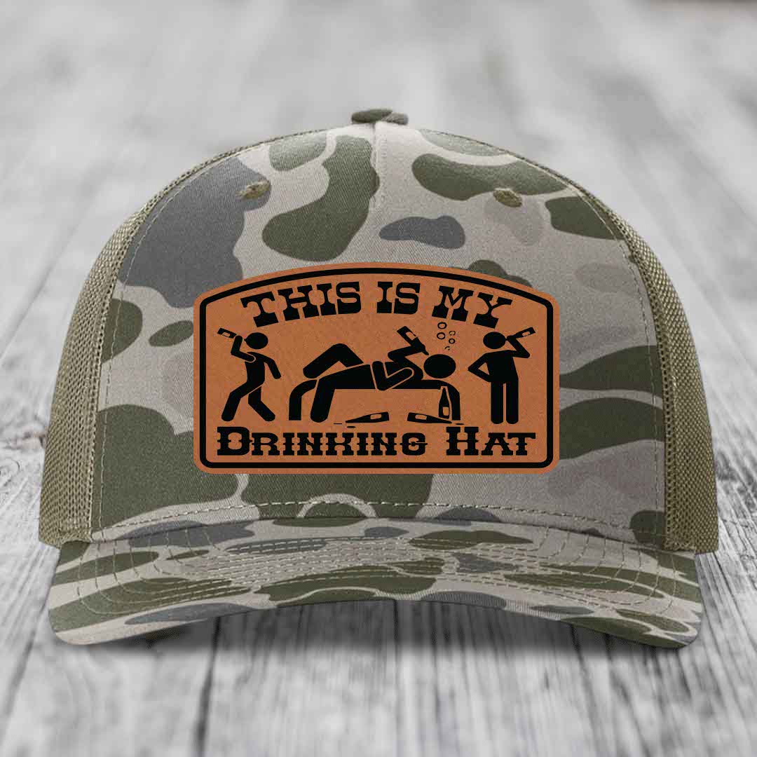 Camouflage trucker hat with brown leather patch reading &