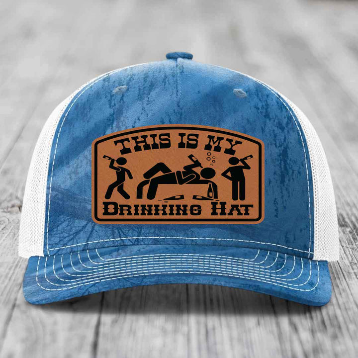 Blue and white trucker hat with a brown leather patch that reads &