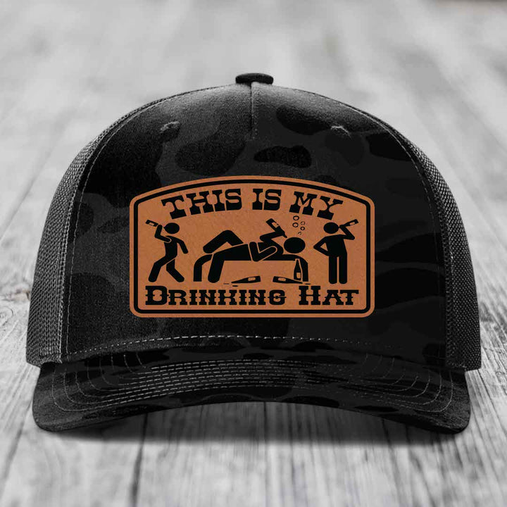 Black camouflage trucker hat with brown leather patch reading &