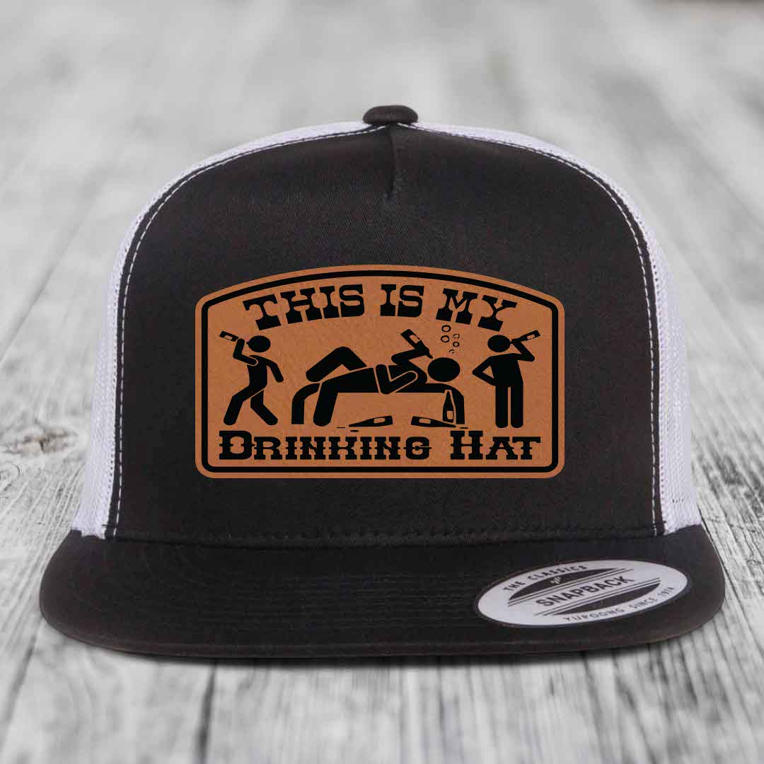 Black and white trucker hat with brown leather patch reading &
