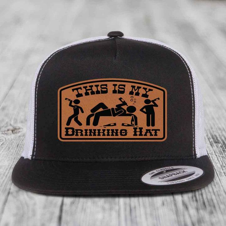 Black and white trucker hat with brown leather patch reading &