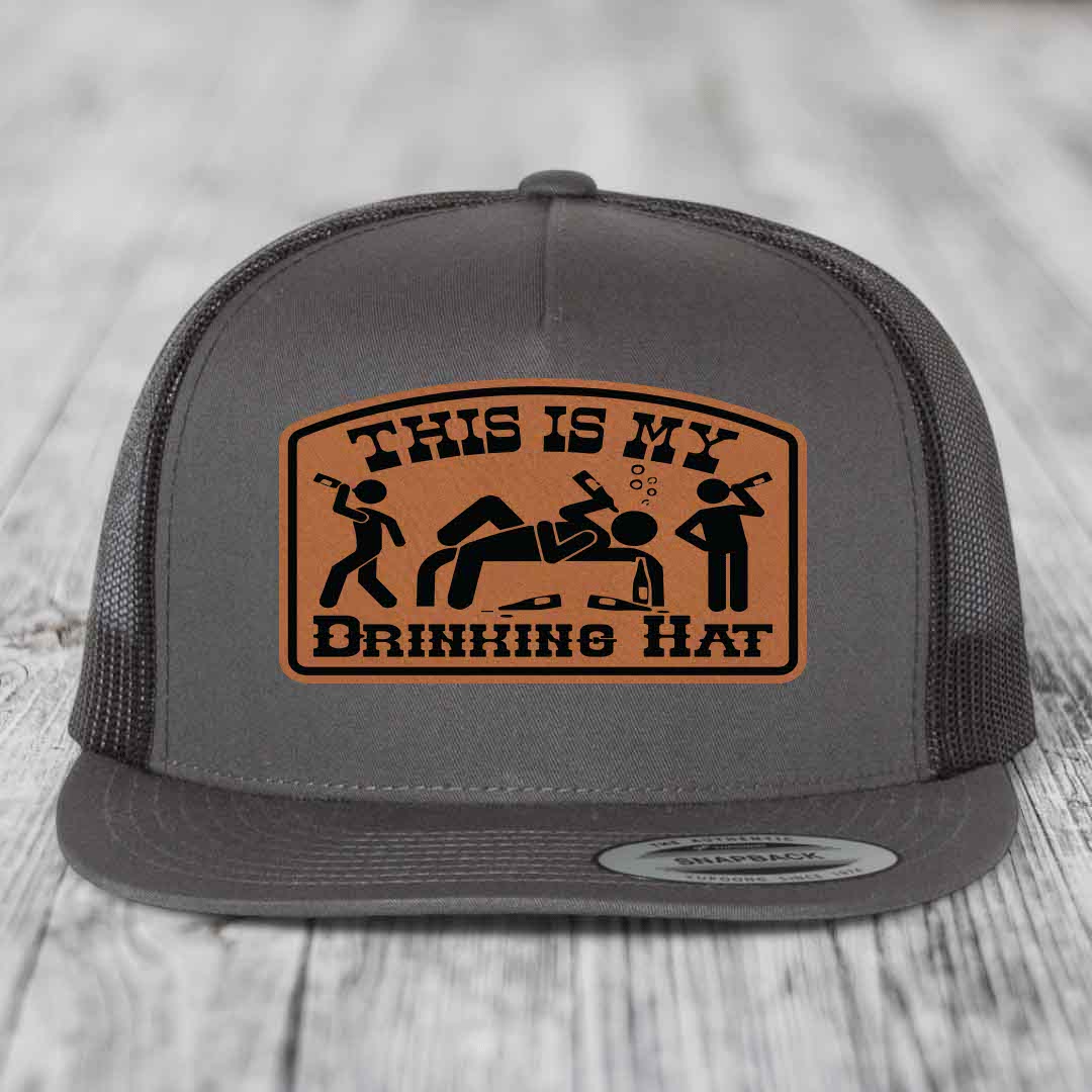 Grey trucker hat with brown leather patch reading &