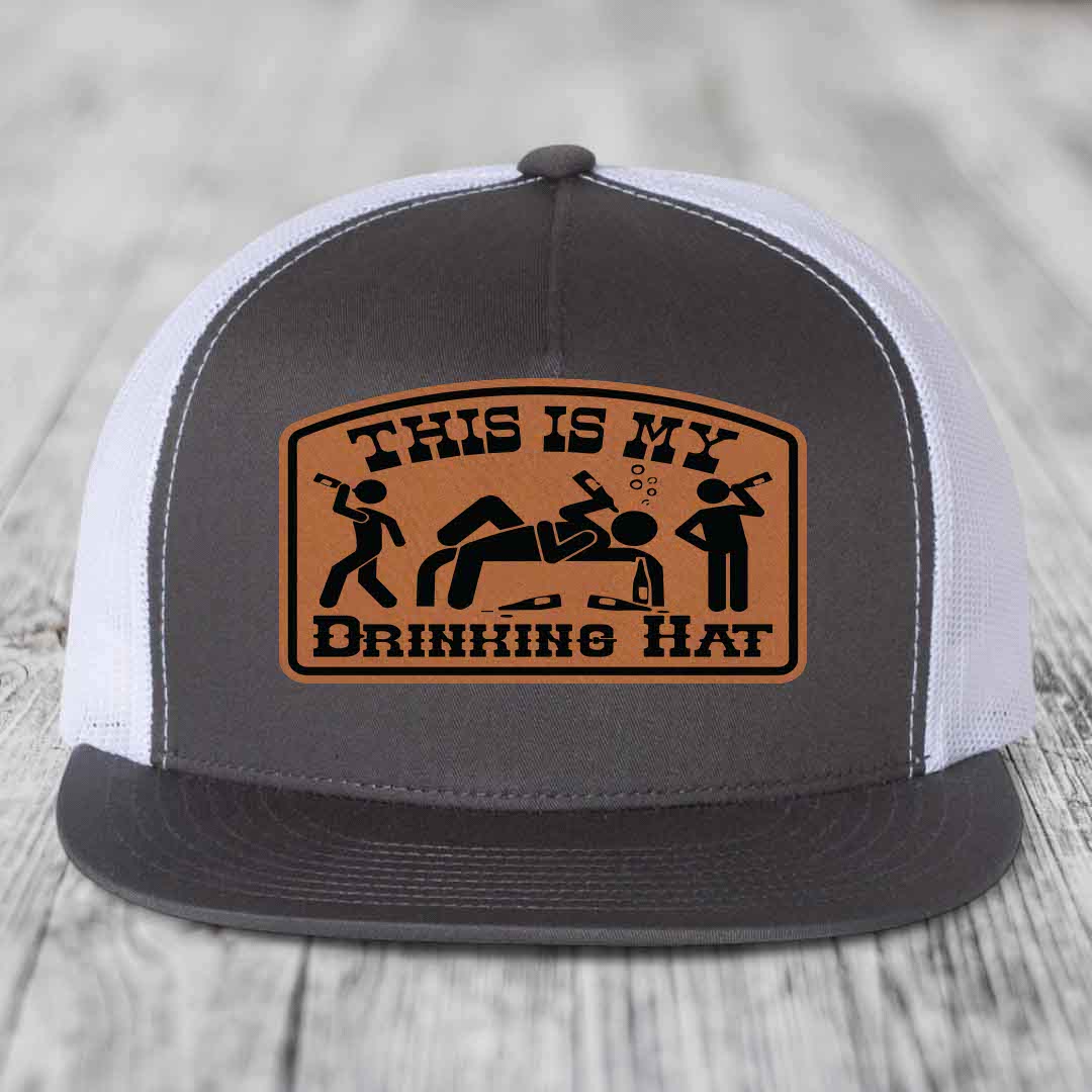 Grey trucker hat with brown leather patch reading &
