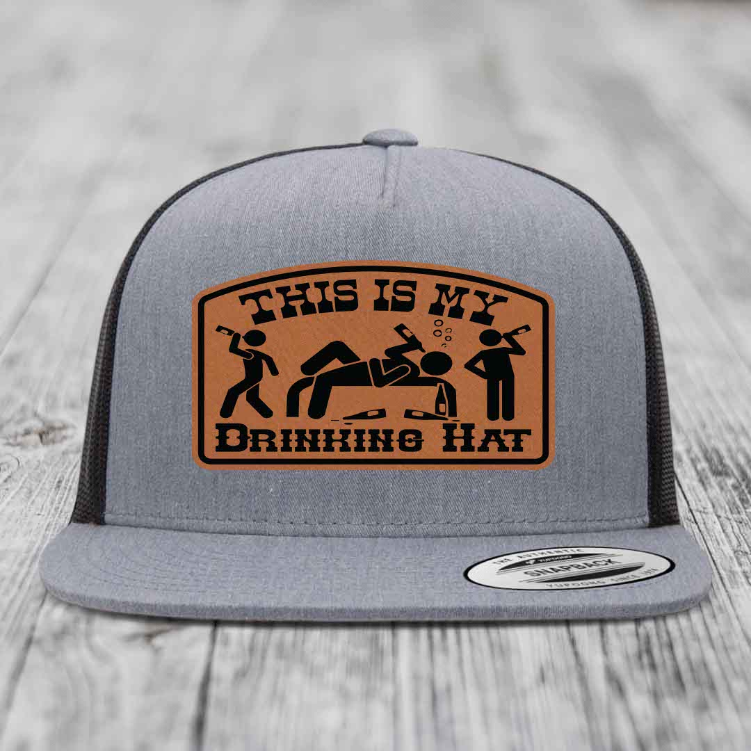 Grey trucker hat with brown leather patch reading &