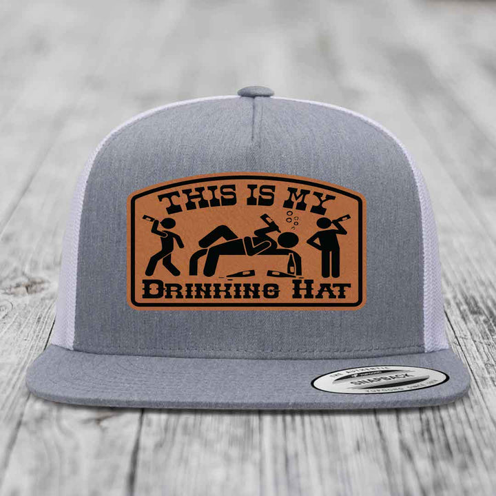 Grey trucker hat with brown leather patch reading &
