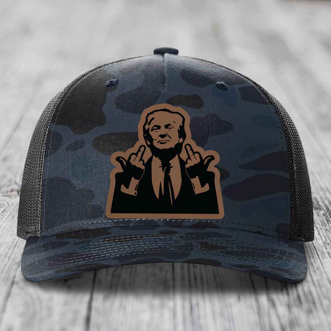 Camouflage trucker hat with a brown and black patch of a man giving two middle fingers.