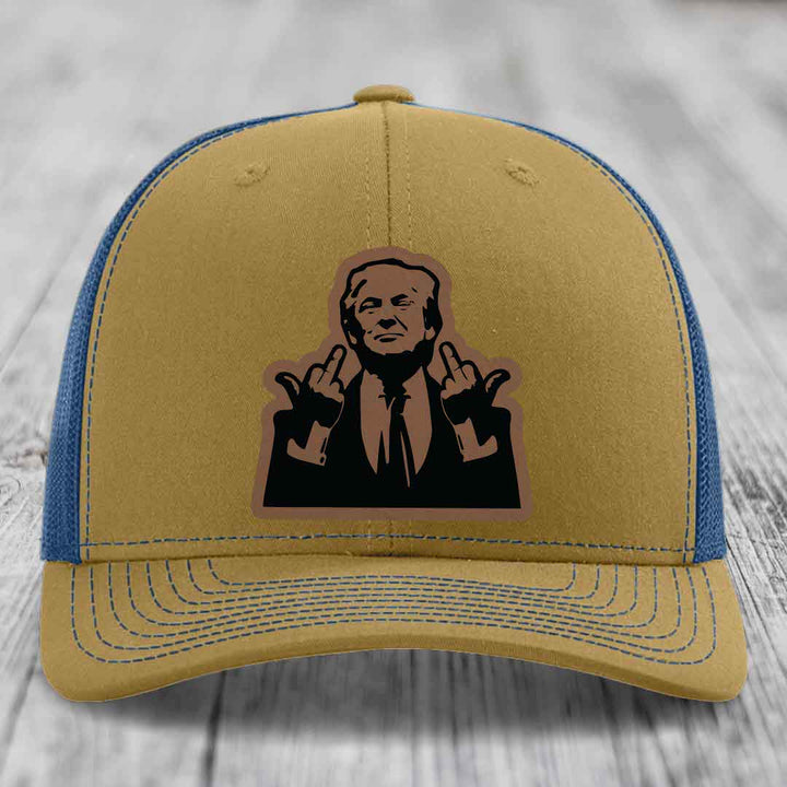 Tan and blue trucker hat with a black leather patch of a man making a hand gesture.