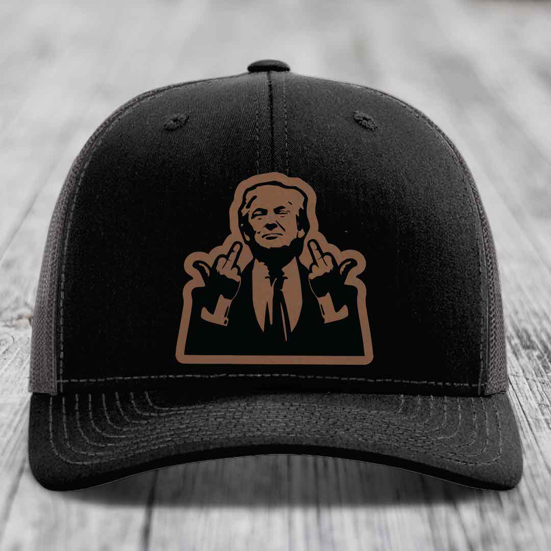 Black trucker hat with brown leather patch of man making rude hand gesture.